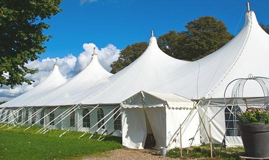 tall green portable restrooms assembled at a music festival, contributing to an organized and sanitary environment for guests in Birdsboro